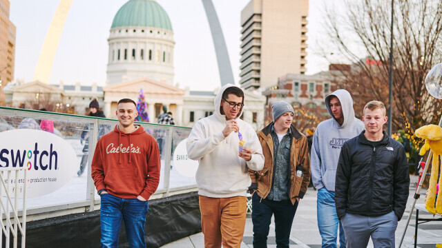 Men walking alongside ice rink with food