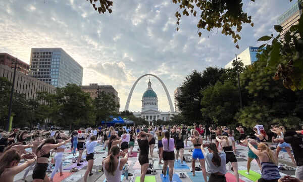 Hundreds of yogis in Kiener Plaza for Gateway Arch Park Foundation Sunrise Yoga