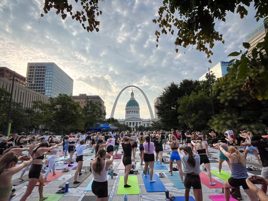 Hundreds of yogis in Kiener Plaza for Gateway Arch Park Foundation Sunrise Yoga
